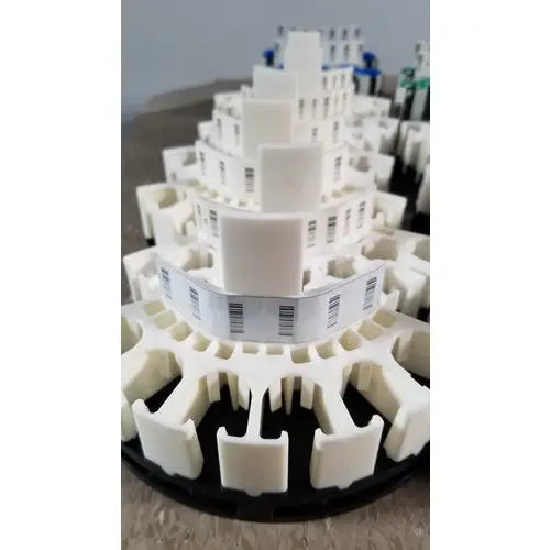 White 3d-printed model of a multi-tiered building complex with barcode labels for grifols cards and dilution trays reuse medical