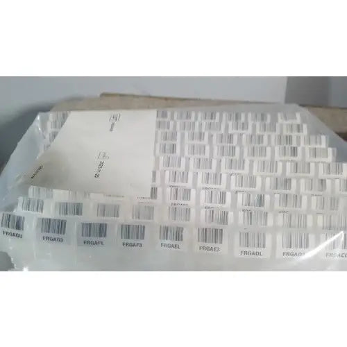 A sheet of white adhesive barcode labels with black and gray stripes and alphanumeric codes for grifols cards reuse medical use