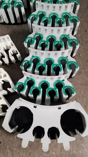 White and green plastic cable clips with black circular inserts for grifols cards dilution trays and evaporation caps