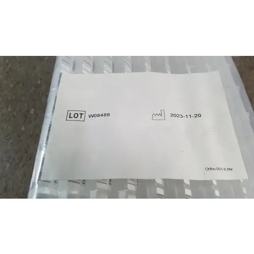 White paper label with black text and icon on clear plastic packaging for grifols cards and dilution trays reuse medical supplies