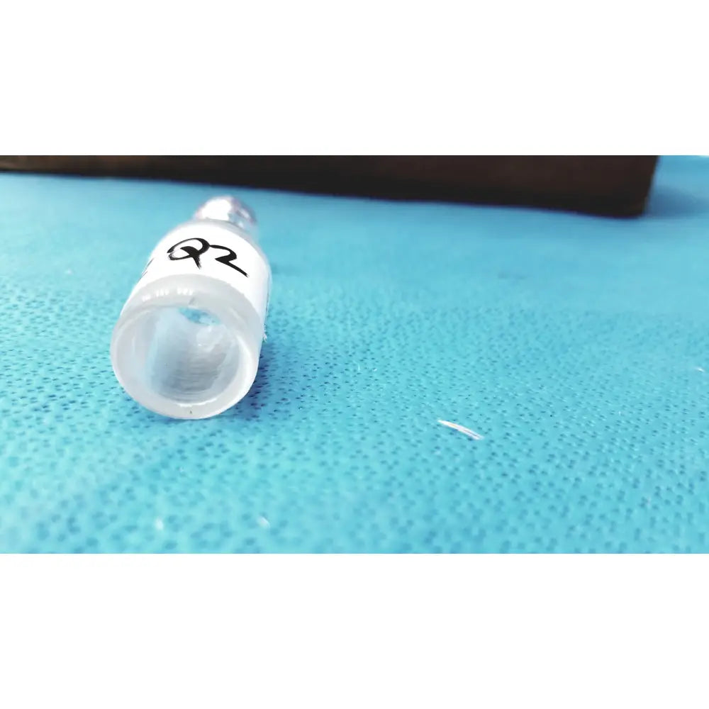 Clear plastic ground glass cone tubing connector lab joint with white label and metallic cap for rubber tubing connection