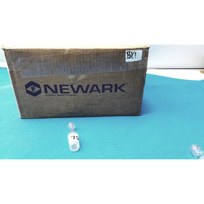A clear plastic vial with silver cap and label marked 20 on blue surface for ground glass cone rubber tubing connector lab use