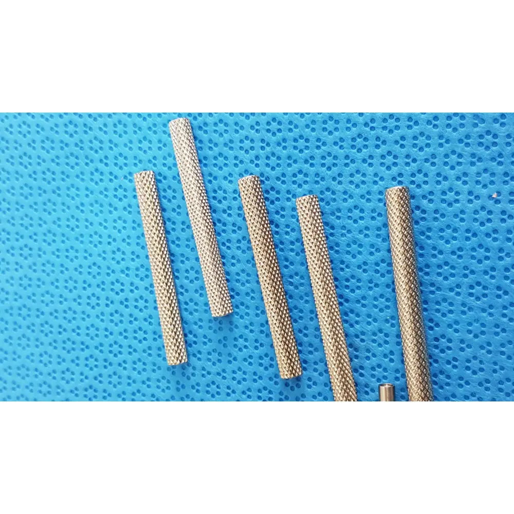 Metallic textured beaver-style scalpel handles with diamond-patterned grip on blue perforated background for precision surgical use