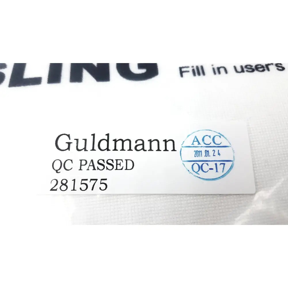 White rectangular label on guldmann disposable micro plus sling max 250kg with black text and a blue quality control stamp
