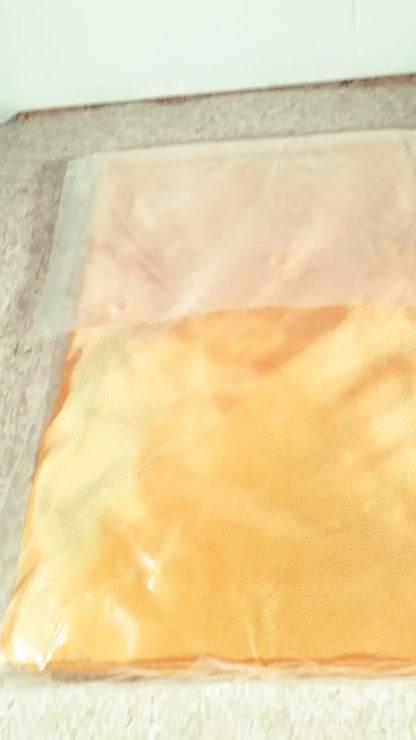 Orange and peach-colored fabric guldmann repositioning sling max 500 kg sealed in clear plastic packaging