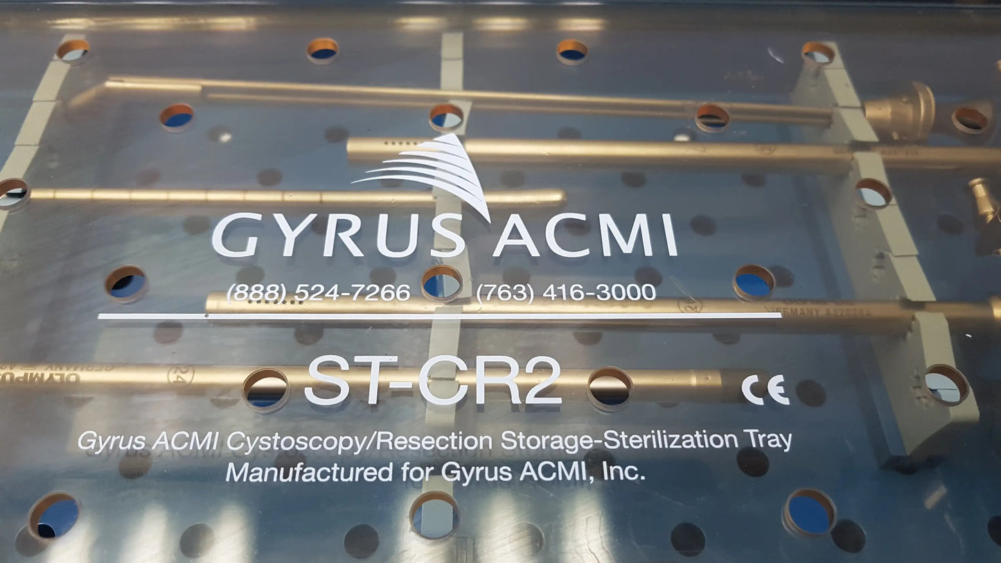 Silver metallic GYRUS ACMI surgical instrument set tray with gold cylindrical rods labeled for cystoscopy and resection use