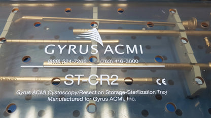 Silver metallic GYRUS ACMI surgical instrument set tray with gold cylindrical rods labeled for cystoscopy and resection use