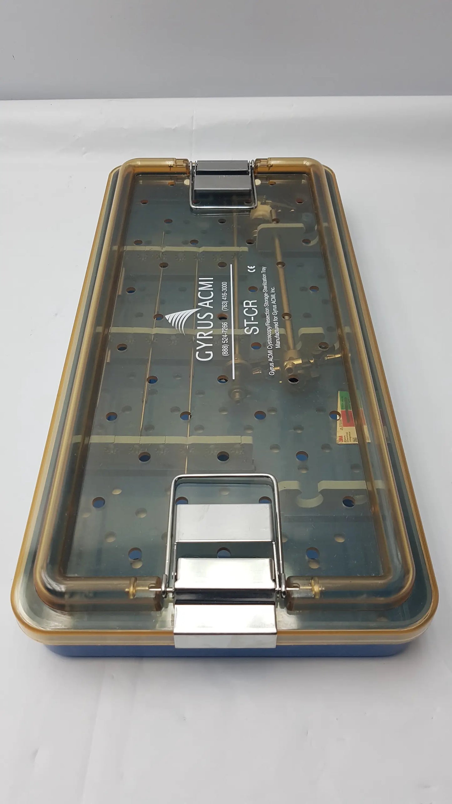 Transparent plastic endoscope sterilization tray with gold metal latches and blue base featuring olympus a3551 urethrotome sheath