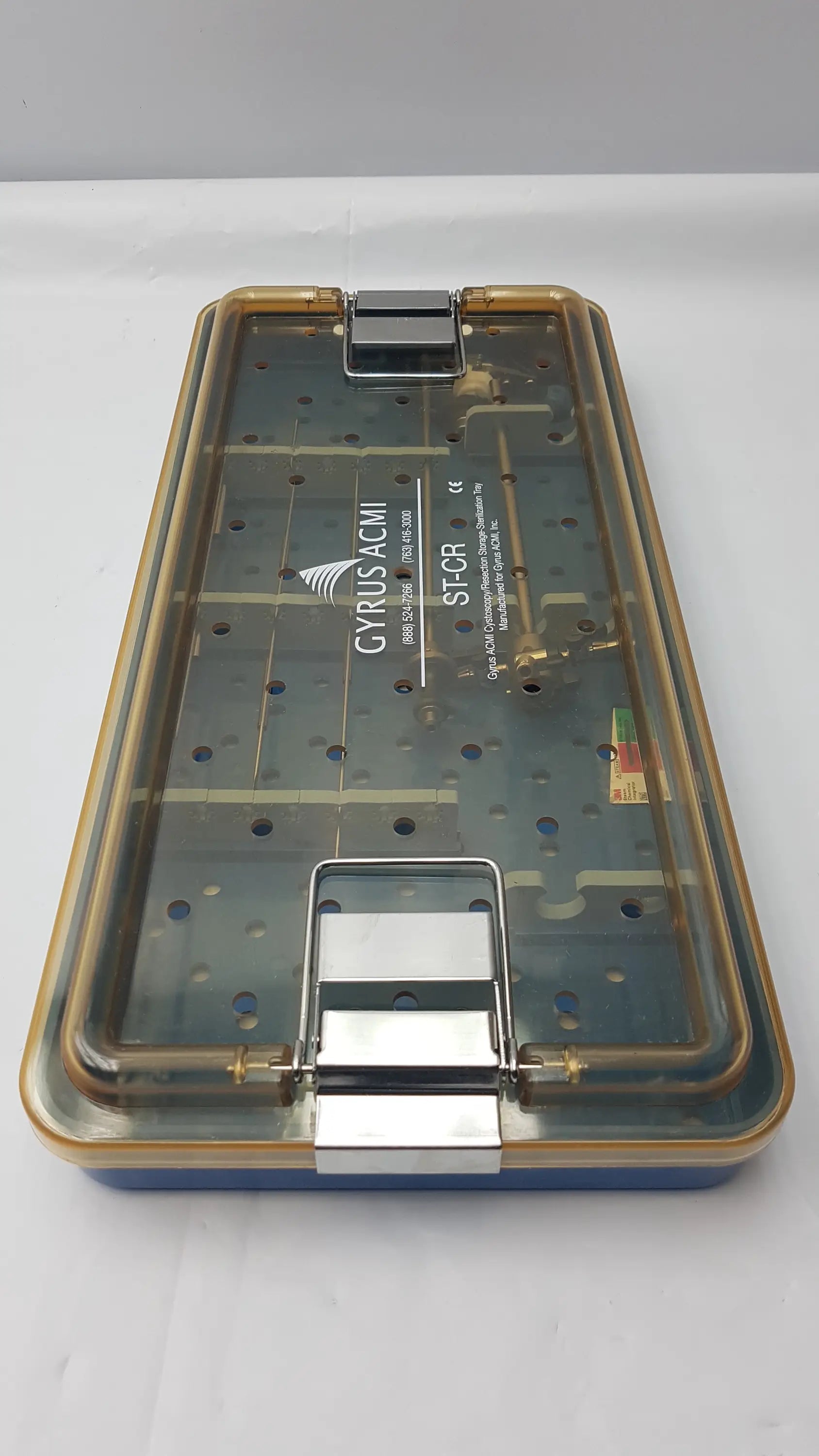 Transparent plastic endoscope sterilization tray with gold metal latches and blue base featuring olympus a3551 urethrotome sheath