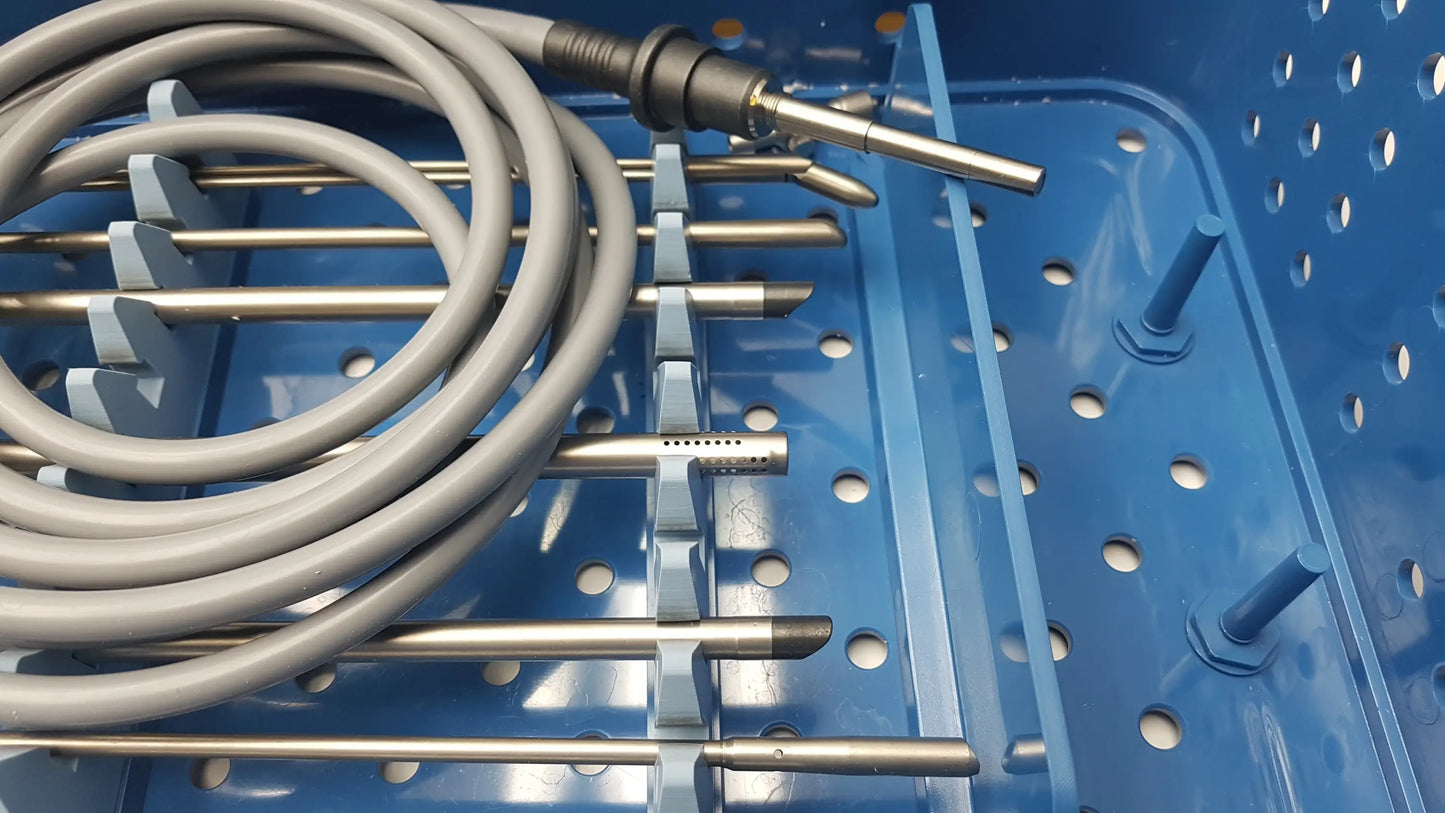 Coiled gray medical tubing with metallic surgical tips in blue gyrus acmi st-cr2 endoscope storage sterilization tray with olympus telescopes