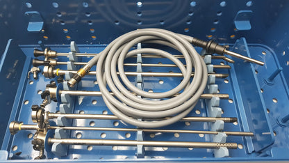 Coiled gray medical tubing with metallic connectors in a blue gyrus acmi endoscope storage sterilization tray for olympus telescopes