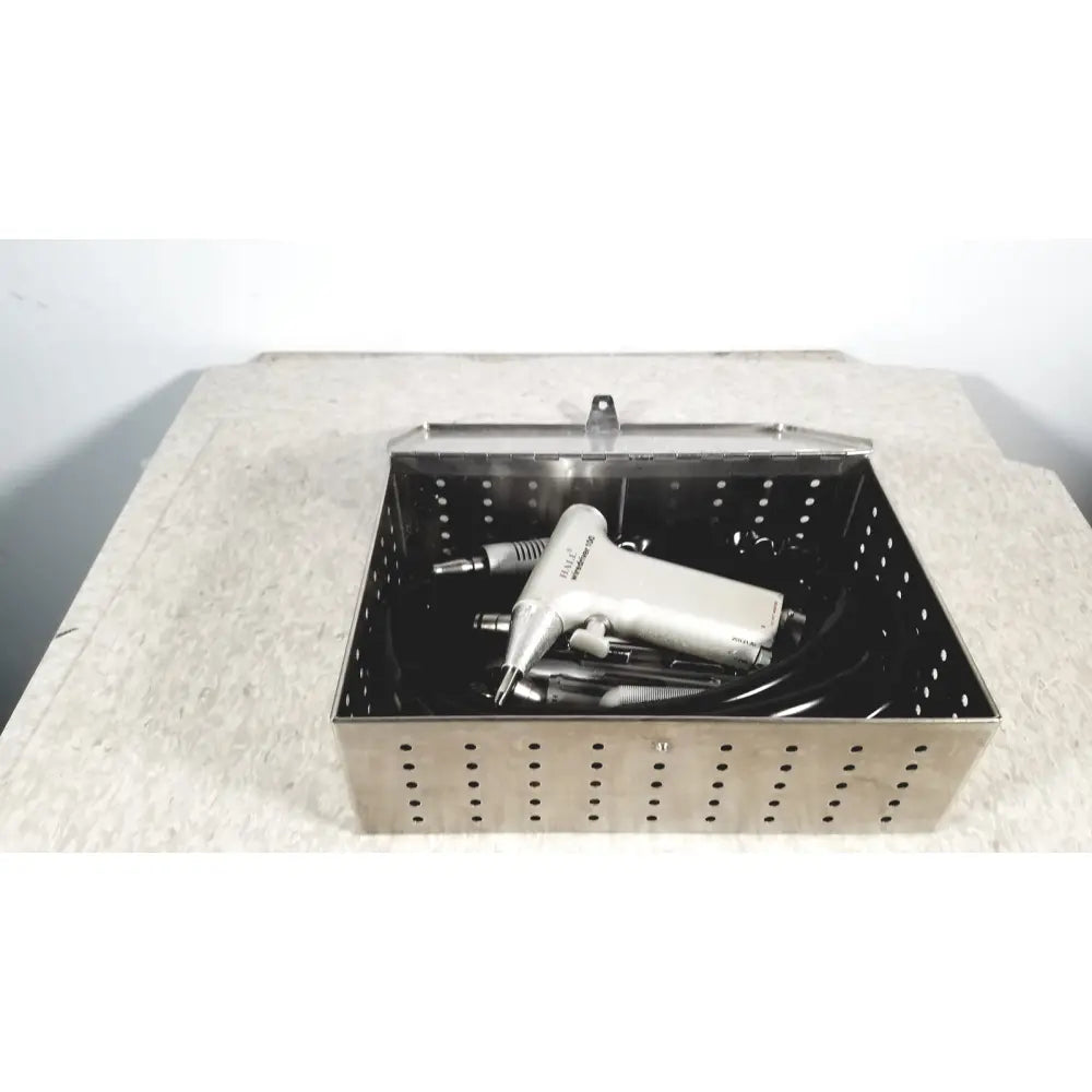 Silver perforated metal surgical instrument sterilizer basket with hinged lid in hall surgical micro 100 set autoclave case