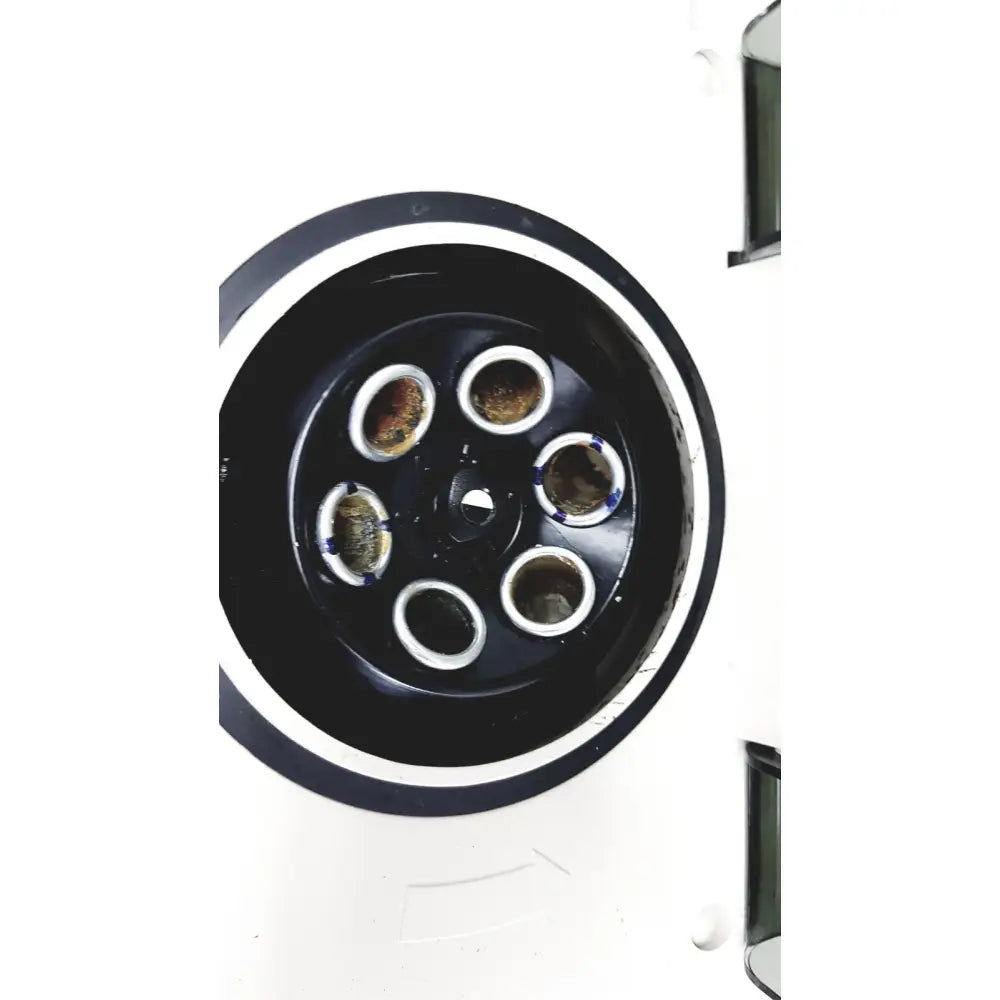 Black circular component of hamilton bell vanguard v6500 6-cell centrifuge with six silver-rimmed openings containing dark substance