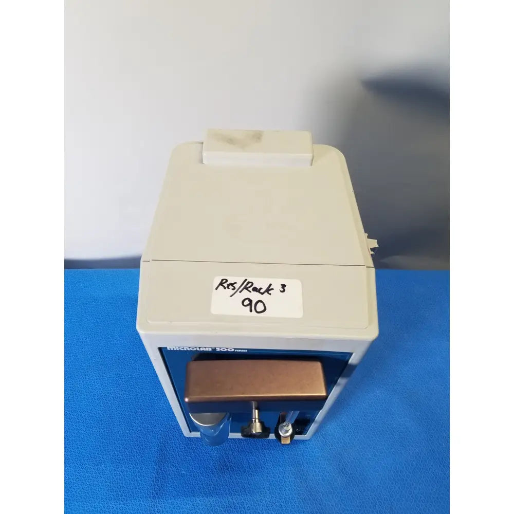 Beige and blue hamilton microlab 300 series syringe pump dispenser with copper-colored sample tray for precise fluid handling