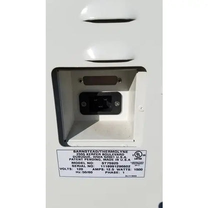 White plastic electrical outlet with black plug and model st7522s label on the back of harvey sterilemax st75935 device
