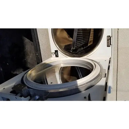 The stainless steel drum of the white harvey sterilemax st75935 front-loading washing machine is open showing its interior components