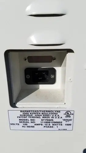 White plastic electrical outlet with black plug and model st7522s label on the back of harvey sterilemax st75935 device