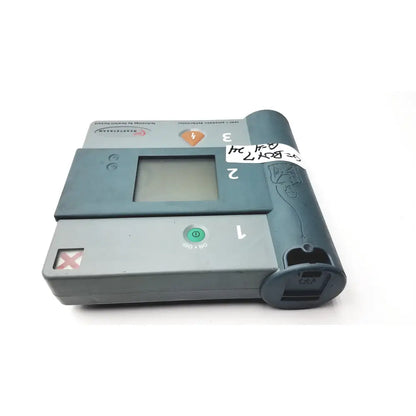 Gray plastic heartstream eo1 semi automatic defibrillator with small screen and green power button for emergency use