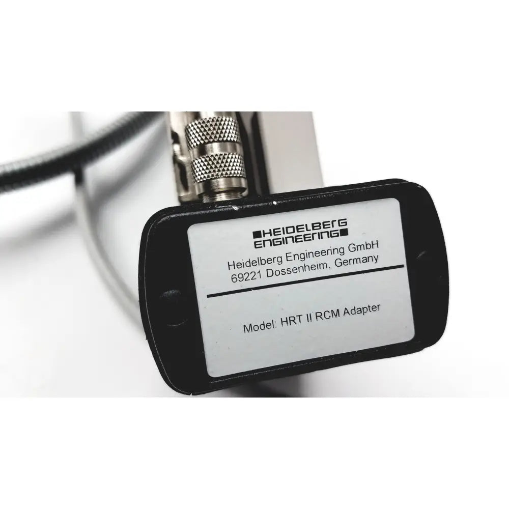 Black rectangular label with white text identifying heidelberg engineering hrti rcm adapter on hrti laser head model lsc210
