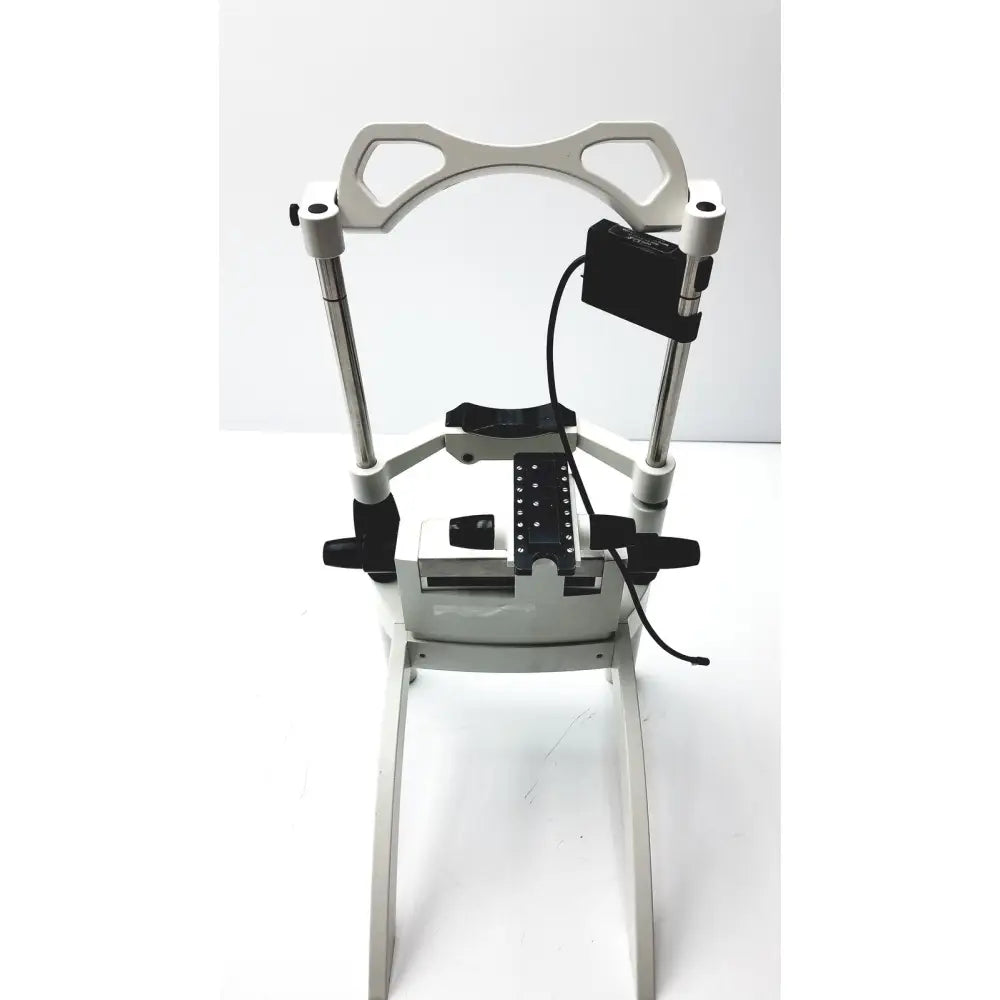 White metal dental chair with black accents and adjustable armrests for Heidelberg Engineering HRTI laser head model LSC210