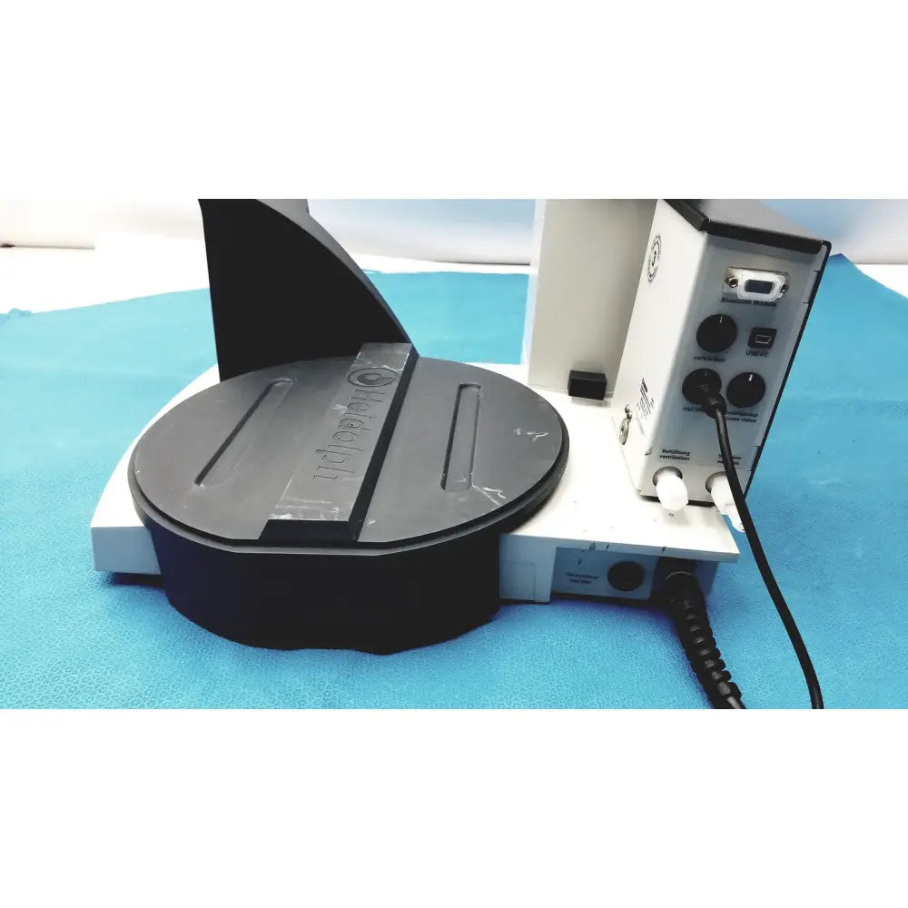 Black circular rotating platform with heidolph basis branding mounted on white base of rotary evaporator unit