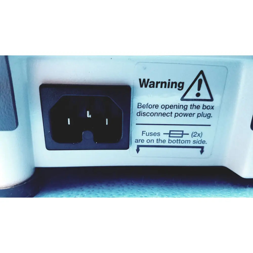 Black electrical plug set in white plastic housing with warning label on back side of heidolph basis hei-vap rotary evaporator