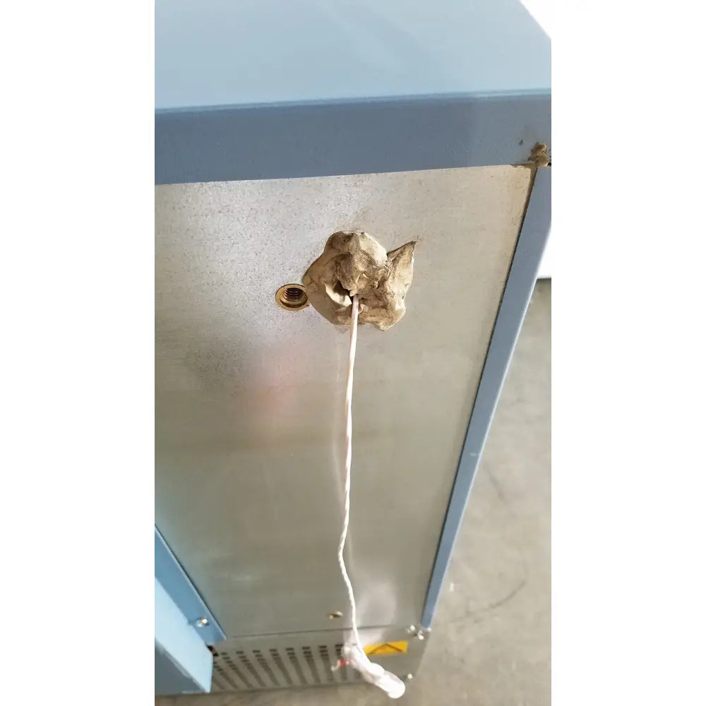 A weathered beige bone-shaped object with rope, shown with helmer hlf105 horizon series laboratory freezer