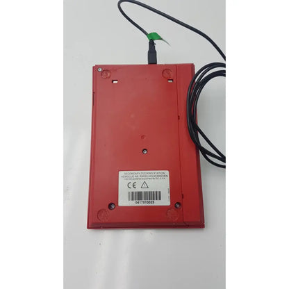 Red plastic secondary docking station with black cable attached to hemocue hb 201 dm hemoglobin system analyzer for reuse medical purposes