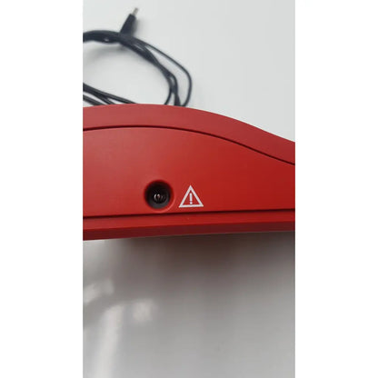 Red plastic reuse medical computer mouse with circular port and warning triangle on underside of hemoCue hb 201 dm analyzer