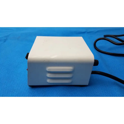 White rectangular henry schein zahn dental laboratory power supply with ventilation slots and black power cord for equipment operation