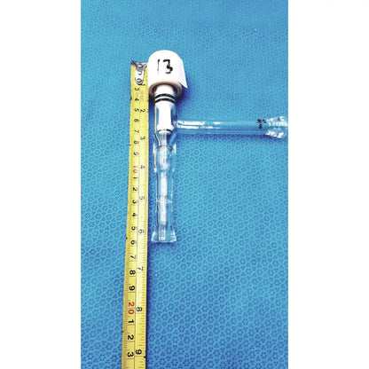 Clear plastic endotracheal tube with white numbered cuff shown with high vacuum lab glass valve teflon coated and durable