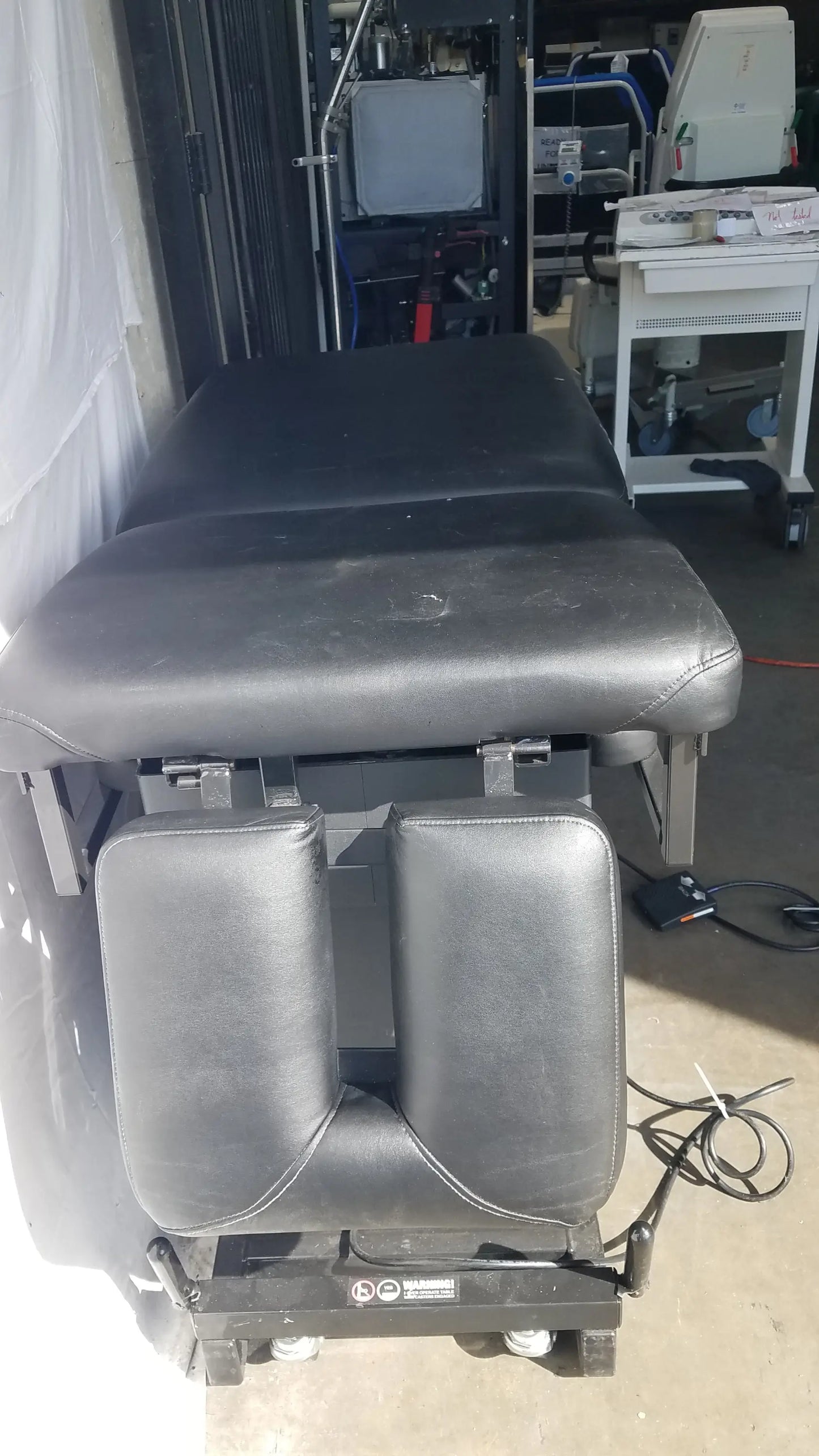 Black leather-adjustable Hill HA90PT physical therapy treatment table with padded sections and wheeled base S/N 231969