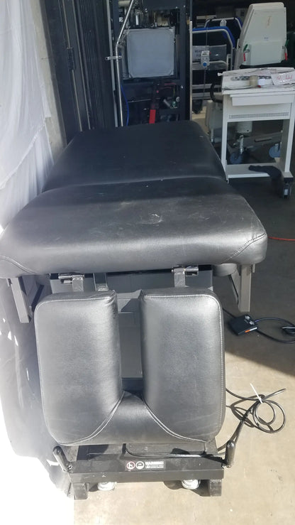 Black leather-adjustable Hill HA90PT physical therapy treatment table with padded sections and wheeled base S/N 231969