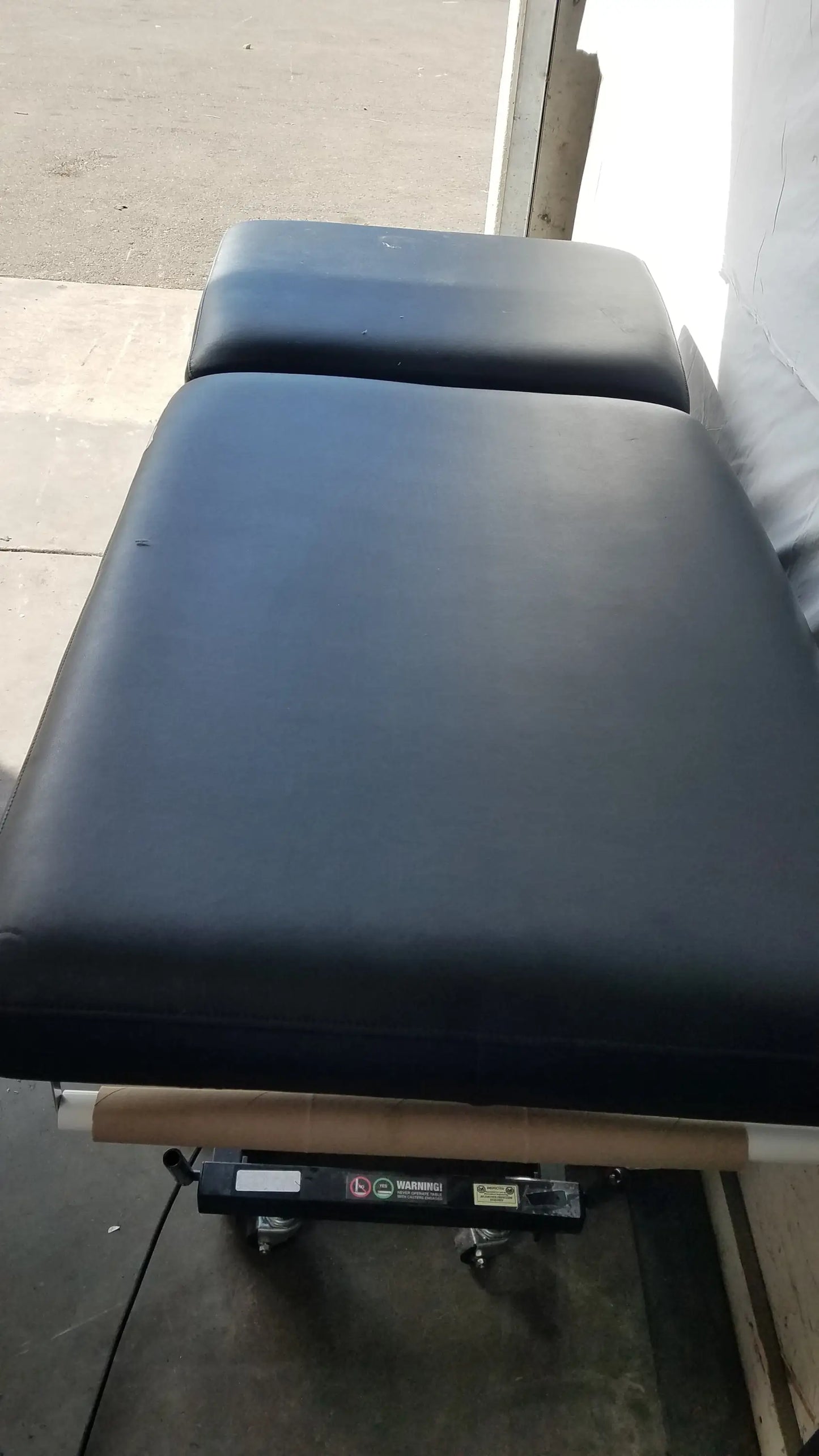 Black Hill HA90PT physical therapy treatment table with padded segmented cushioning and wheeled base for mobilization