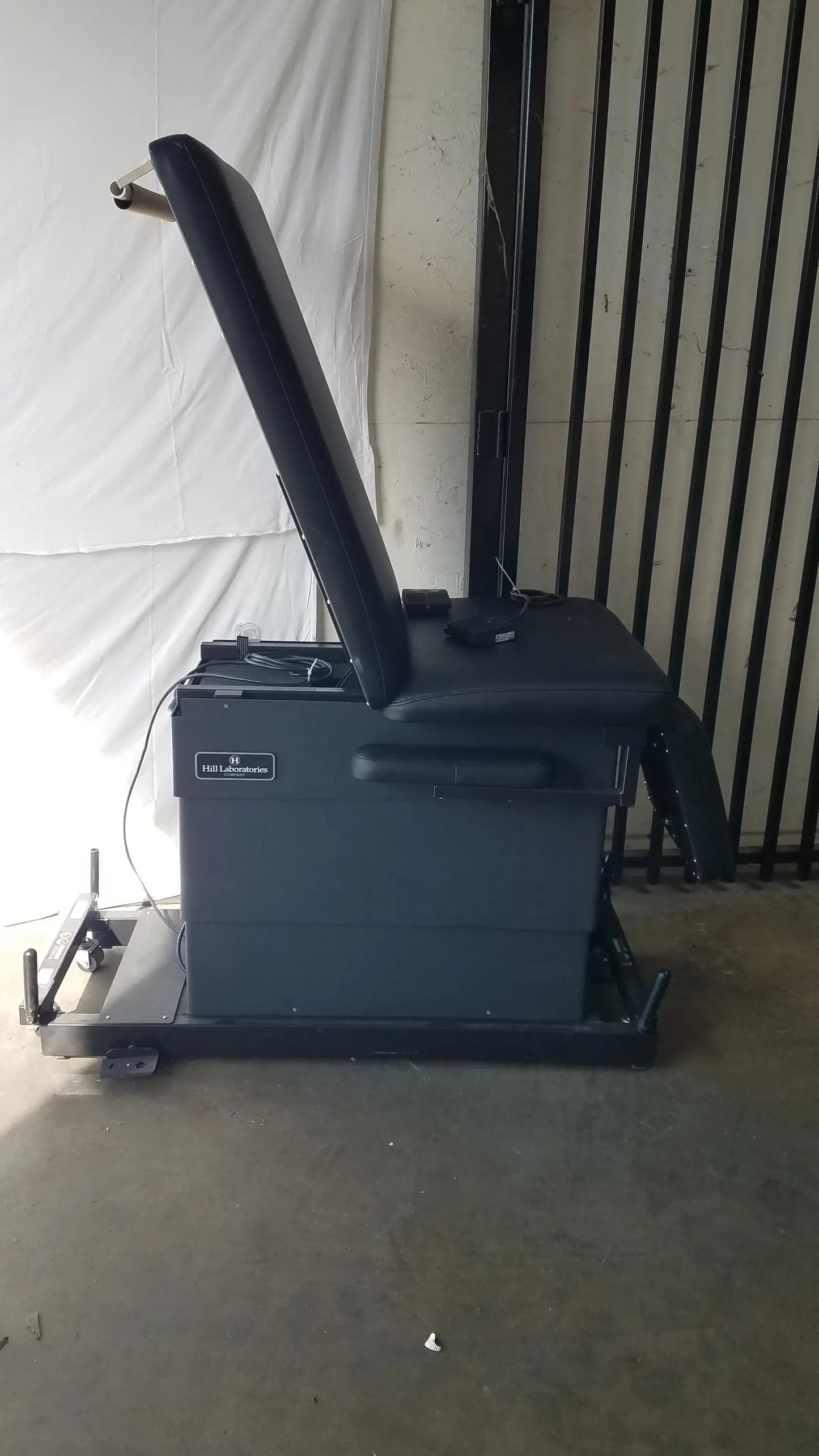 Black leather physical therapy treatment chair with reclining feature, adjustable headrest, footrest, and metal frame