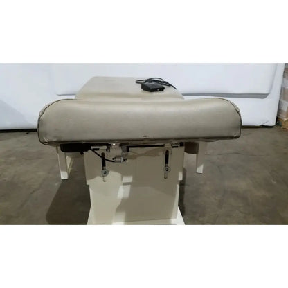 Beige upholstered hill model ha90pt physical therapy treatment table with padded headrest and metal frame