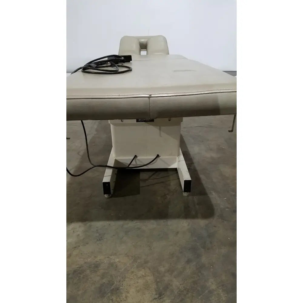 Beige padded Hill model ha90pt physical therapy treatment table with adjustable headrest and metal frame