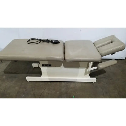 Beige upholstered hull brand hill model ha90pt physical therapy treatment table with segmented pads and adjustable headrest