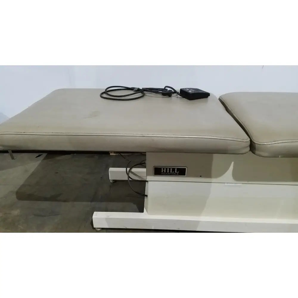 Beige upholstered hill model ha90pt physical therapy treatment table with adjustable height and black power cord control unit