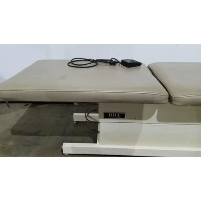Beige upholstered hill model ha90pt physical therapy treatment table with adjustable height and black power cord control unit