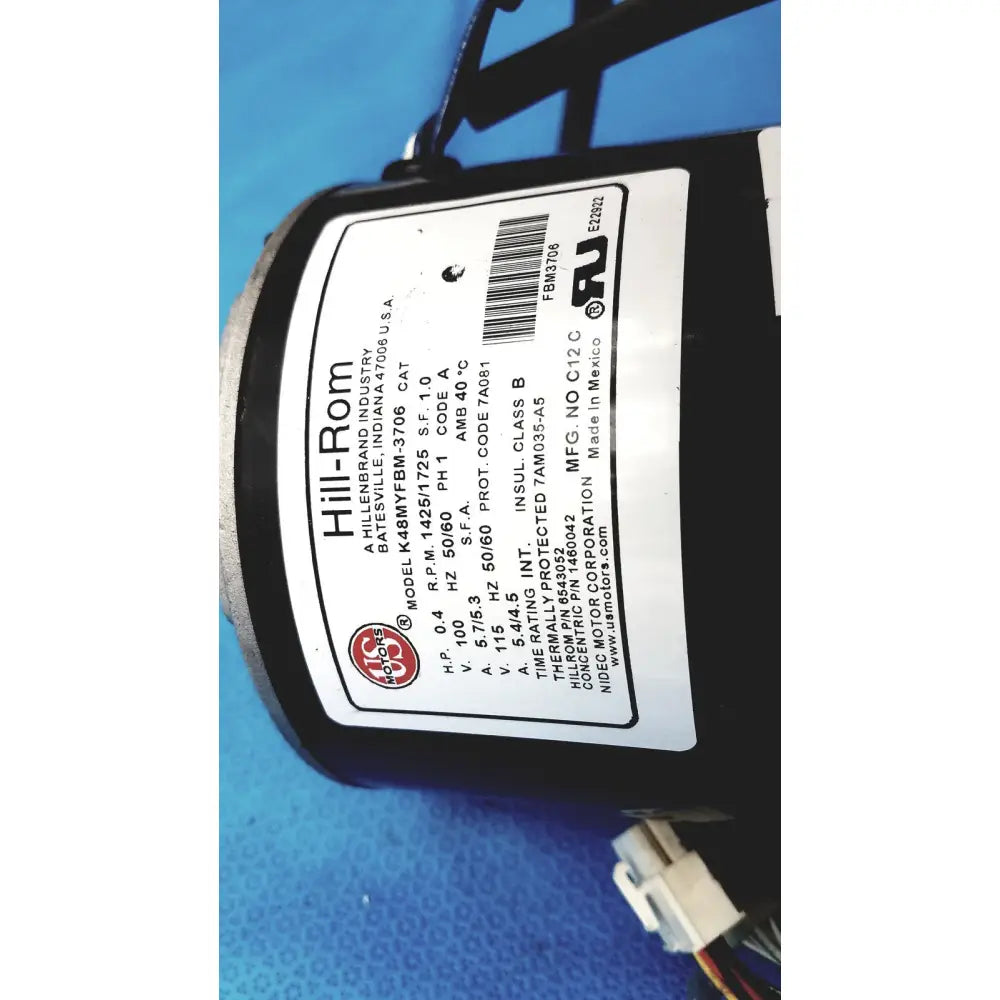 Black cylindrical hill-rom totalcare bed hydraulic power unit with white label displaying technical specifications