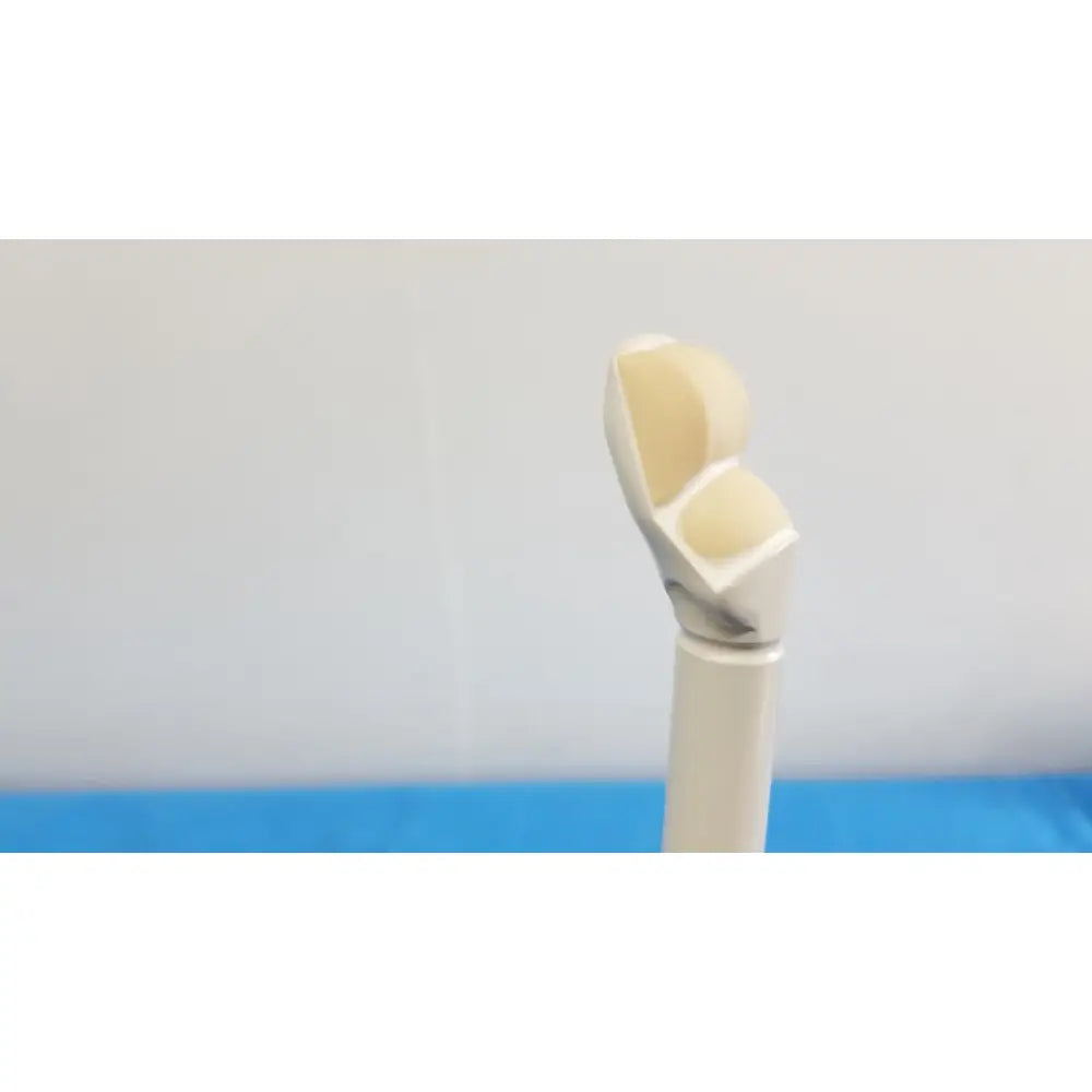 A beige and white smooth curved prosthetic finger alongside the hitachi cc41r ultrasound probe 8-4 mhz device
