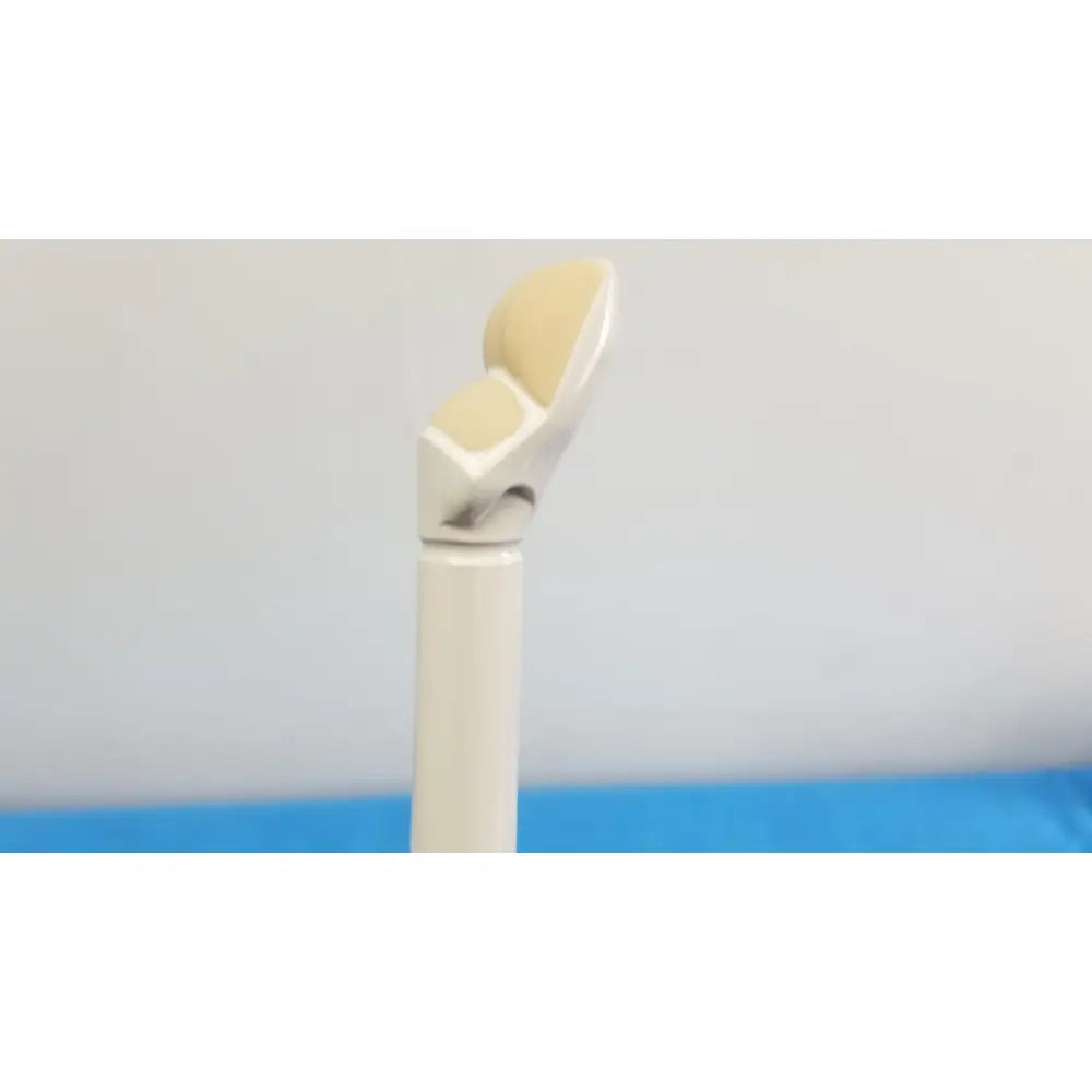 A beige and silver prosthetic knee joint with smooth curves shown alongside the hitachi cc41r ultrasound probe 8 4 mhz