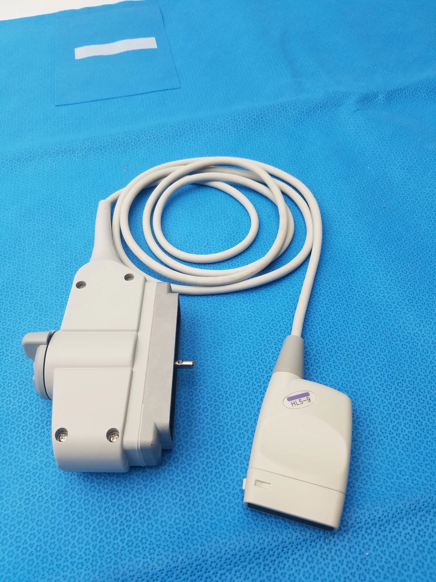 Hl5-9ed gray linear ultrasound transducer probe with coiled cable and labeled handle for precise ultrasound imaging