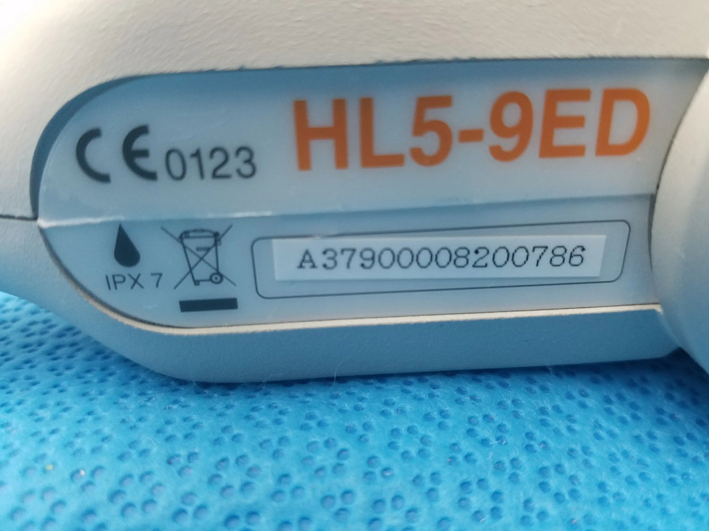 Light blue plastic hl5-9ed linear ultrasound transducer probe with orange labeling and serial number sticker for ultrasound imaging