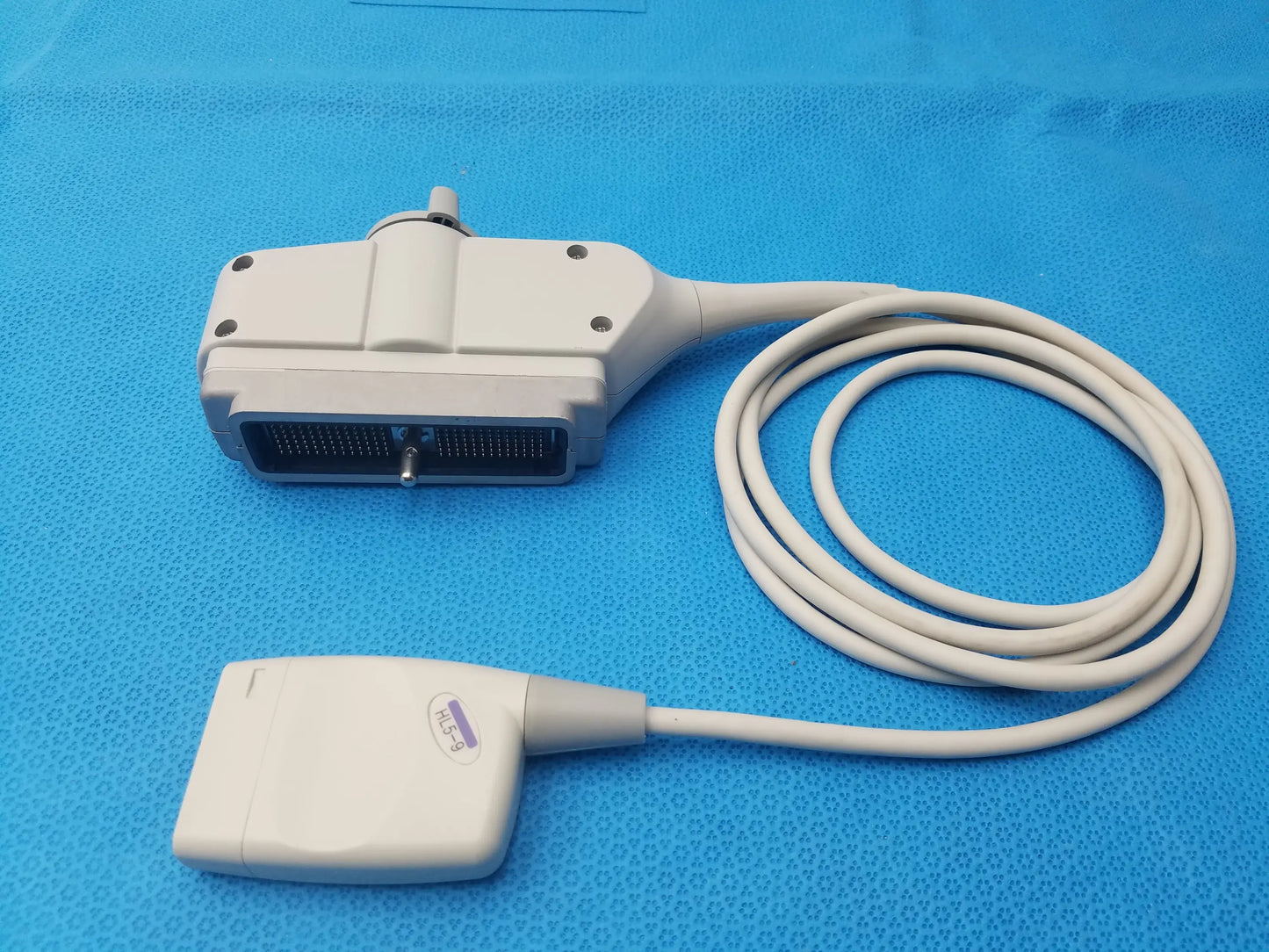 Hl5-9ed white linear ultrasound transducer probe with coiled cable and purple label for ultrasound imaging use