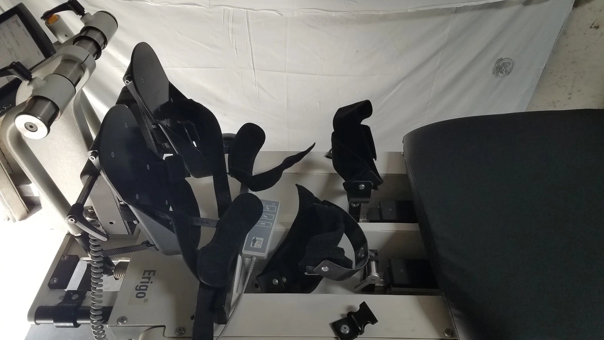 Black padded seat and leg support assembly of hocoma erigo pro robotic tilt table for verticalization therapy