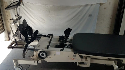 Beige hocoma erigo pro robotic tilt table with black padded surface and adjustable leg support for verticalization therapy