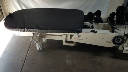 White medical robotic tilt table with black padded surface and hocoma erigo branding for verticalization therapy