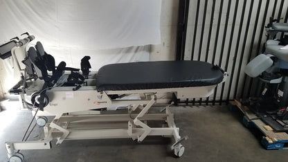 White hocoma erigo pro robotic tilt table with black padded surface and adjustable armrests for verticalization therapy